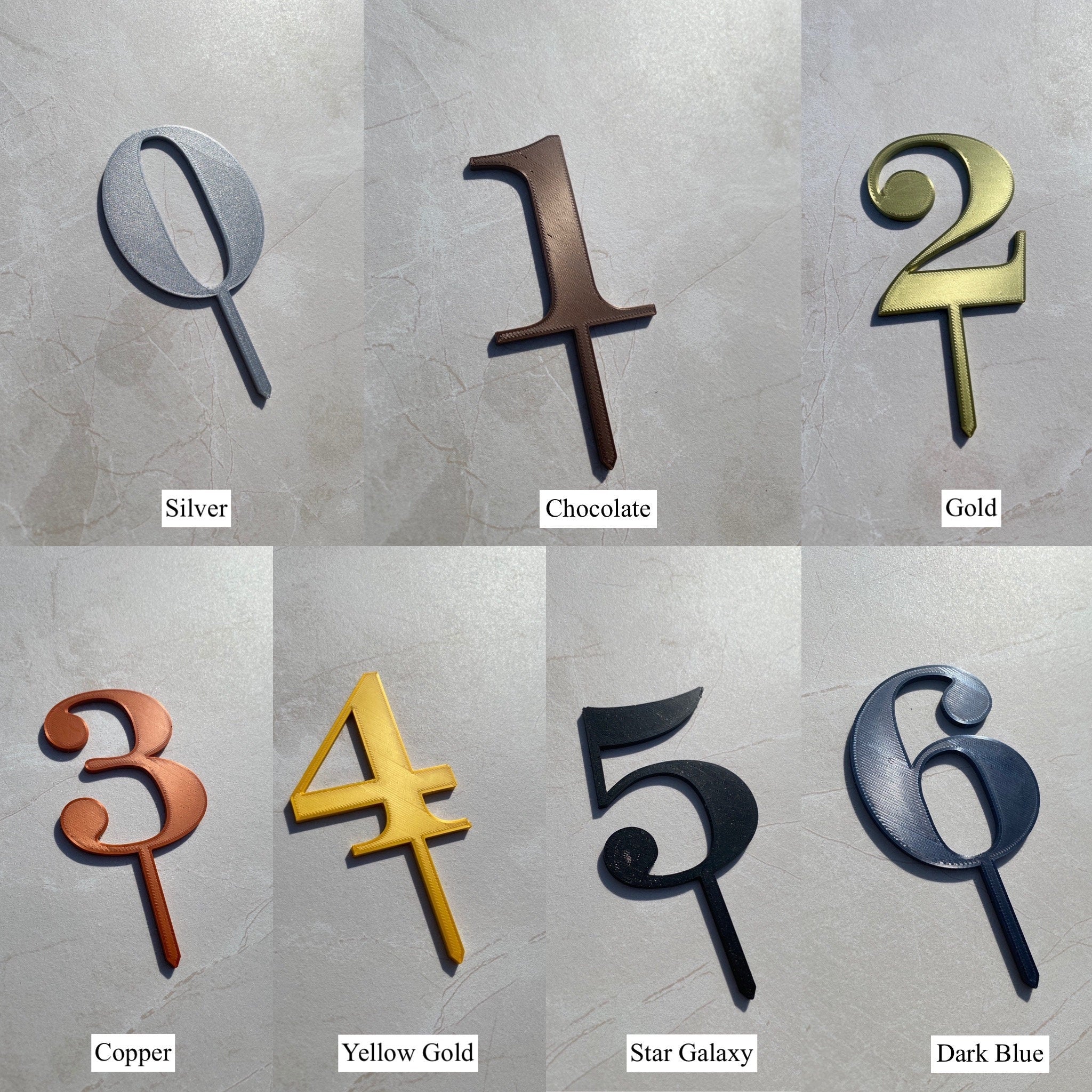 Cake topper numbers in metallic finishes including silver, chocolate, gold, copper, star galaxy and dark blue