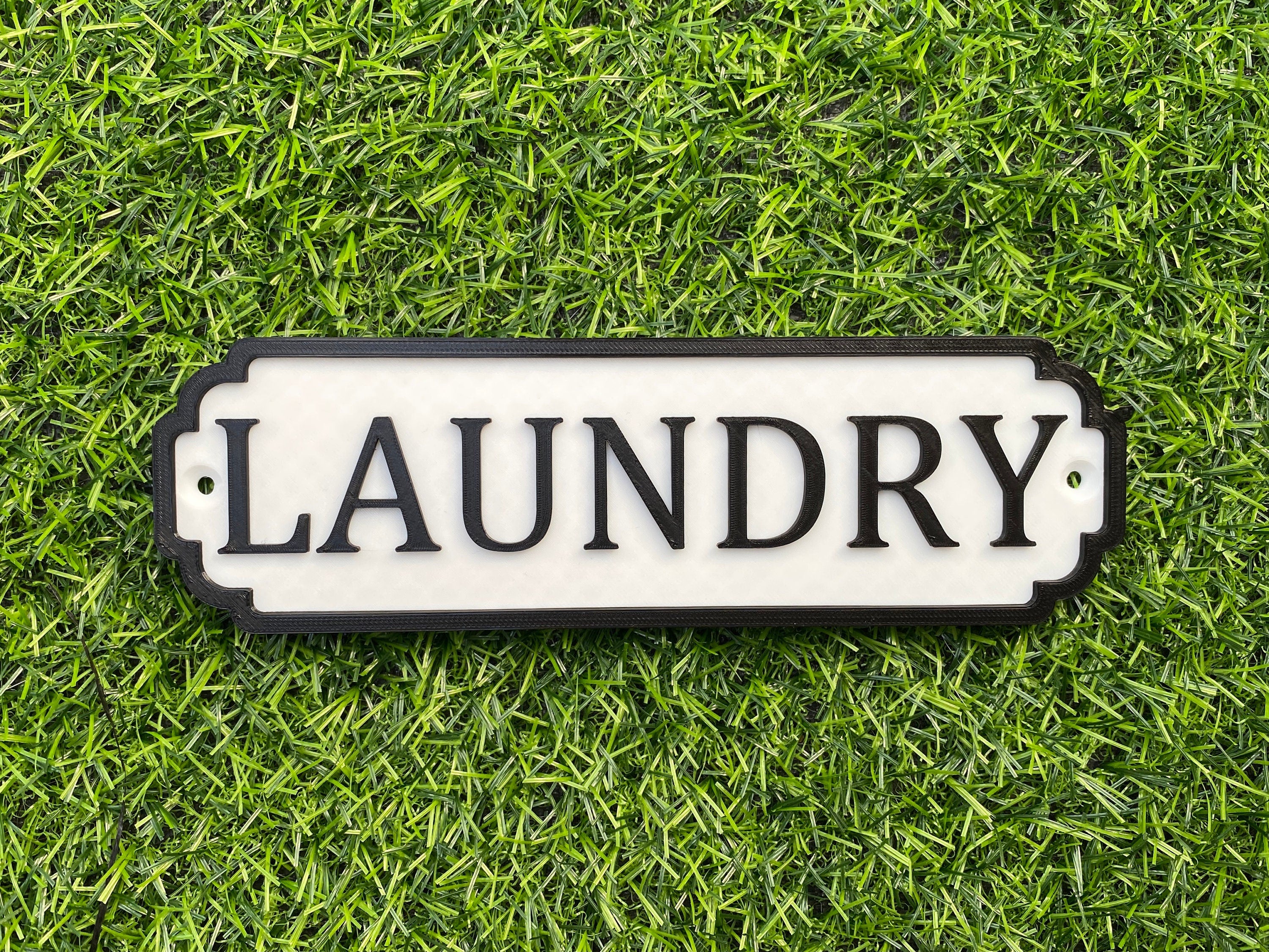 White and black classic door sign reading Laundry