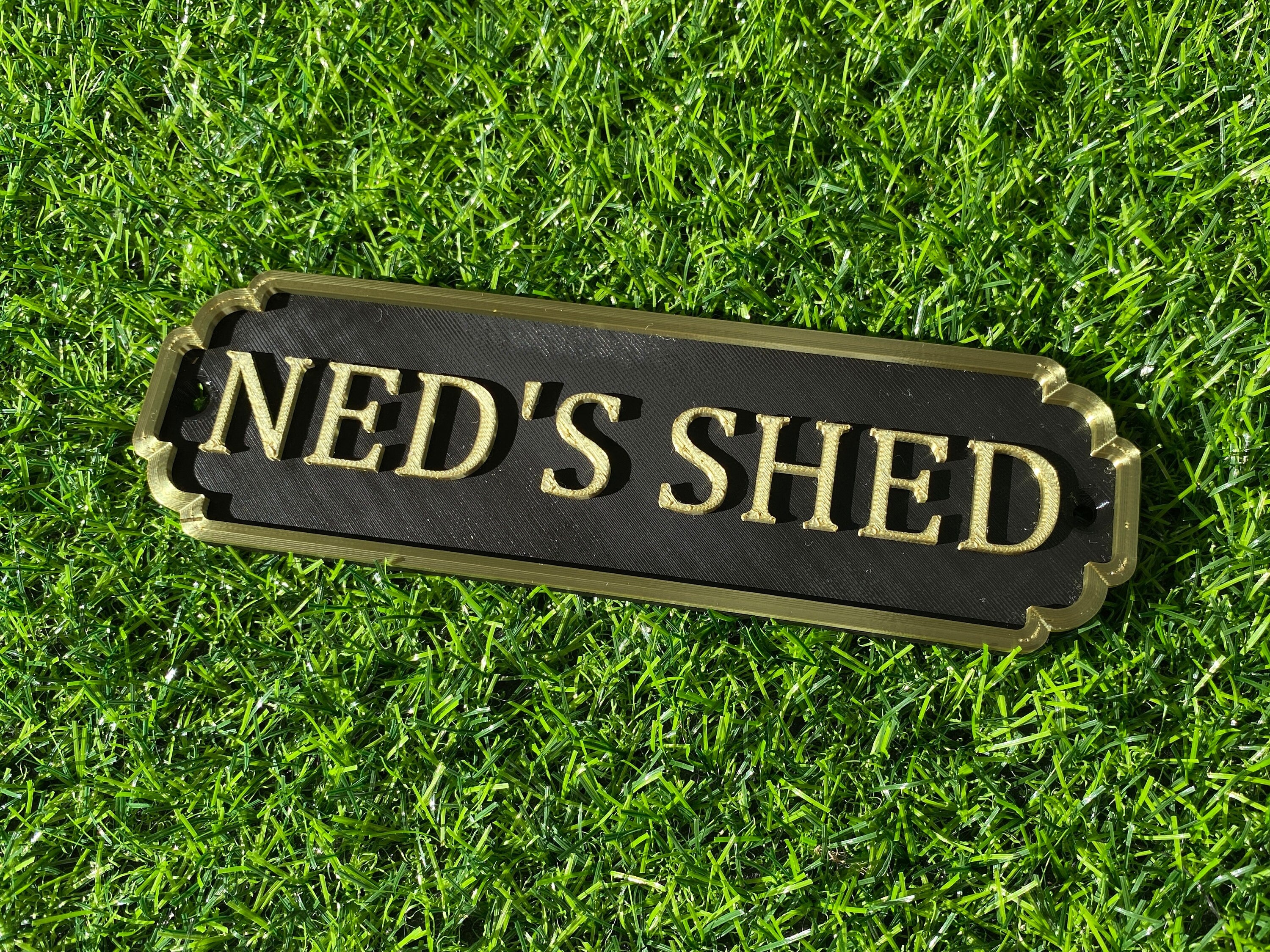 Black and gold classic door sign reading Ned's Shed