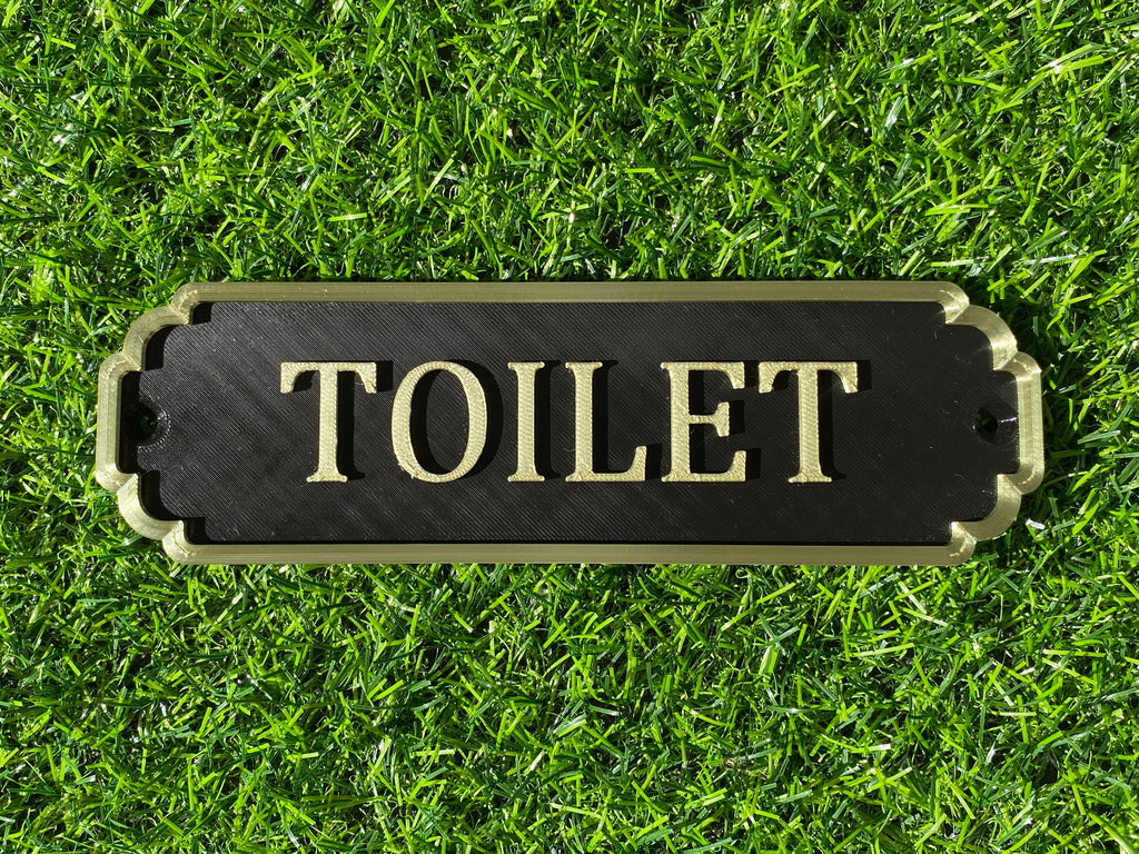 Black and gold classic door sign reading Toilet