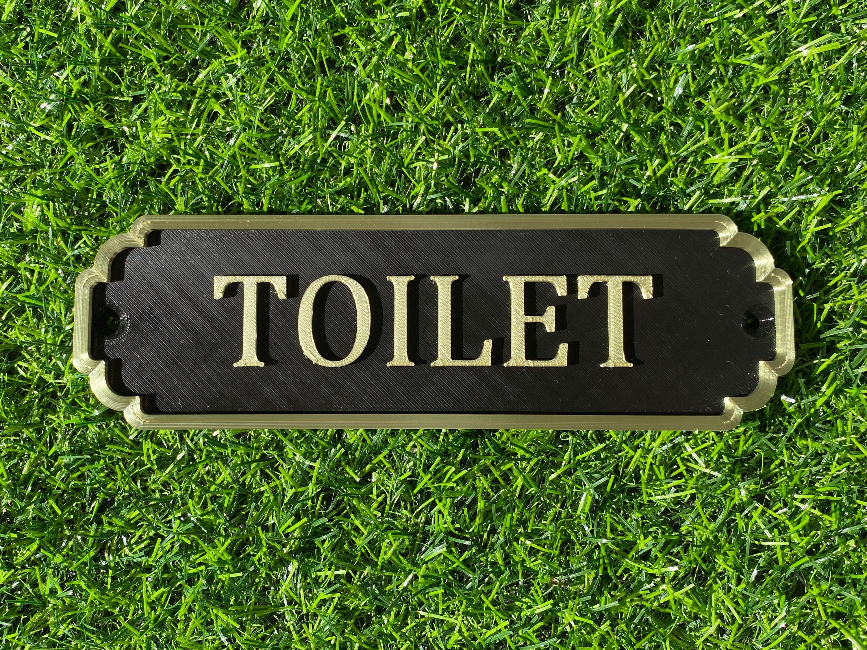Black and gold classic door sign reading Toilet