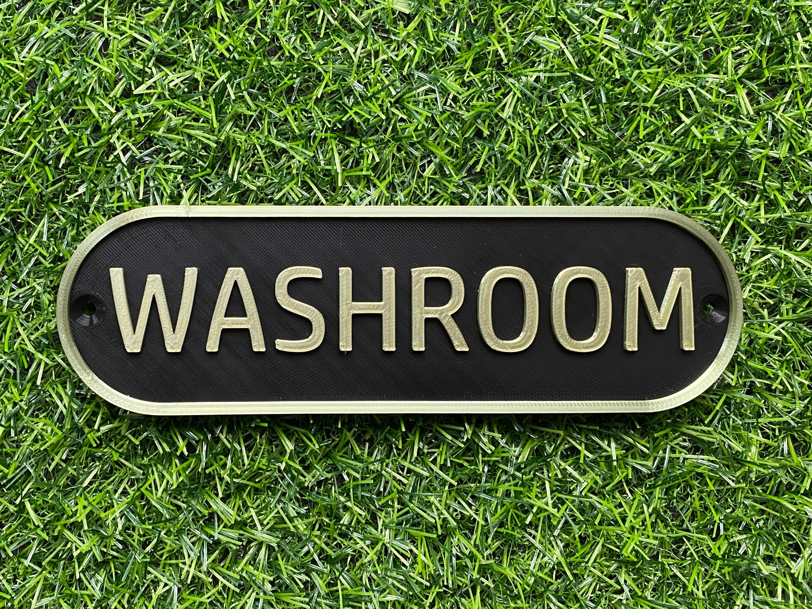 Black and gold retro door sign reading Washroom