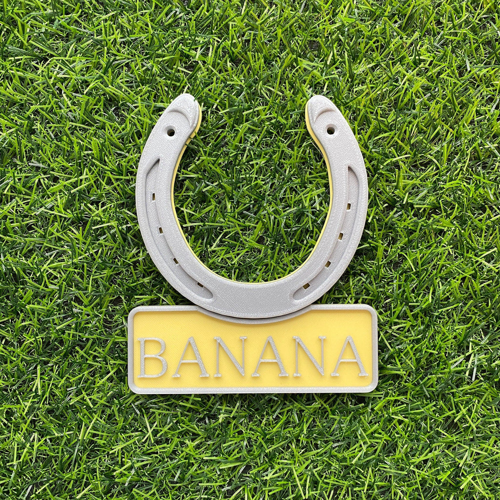 Yellow personalised horseshoe name plate with a silver horseshoe, name Banana