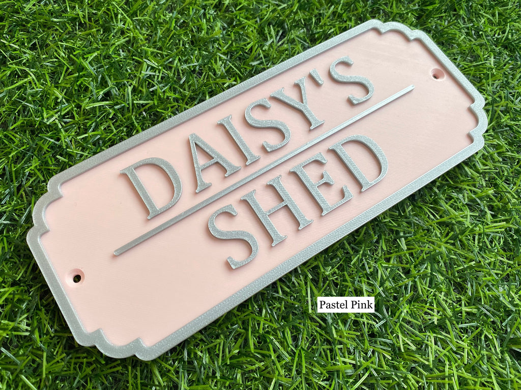 Pastel pink rabbit hutch sign with silver lettering reading Daisy's Shed