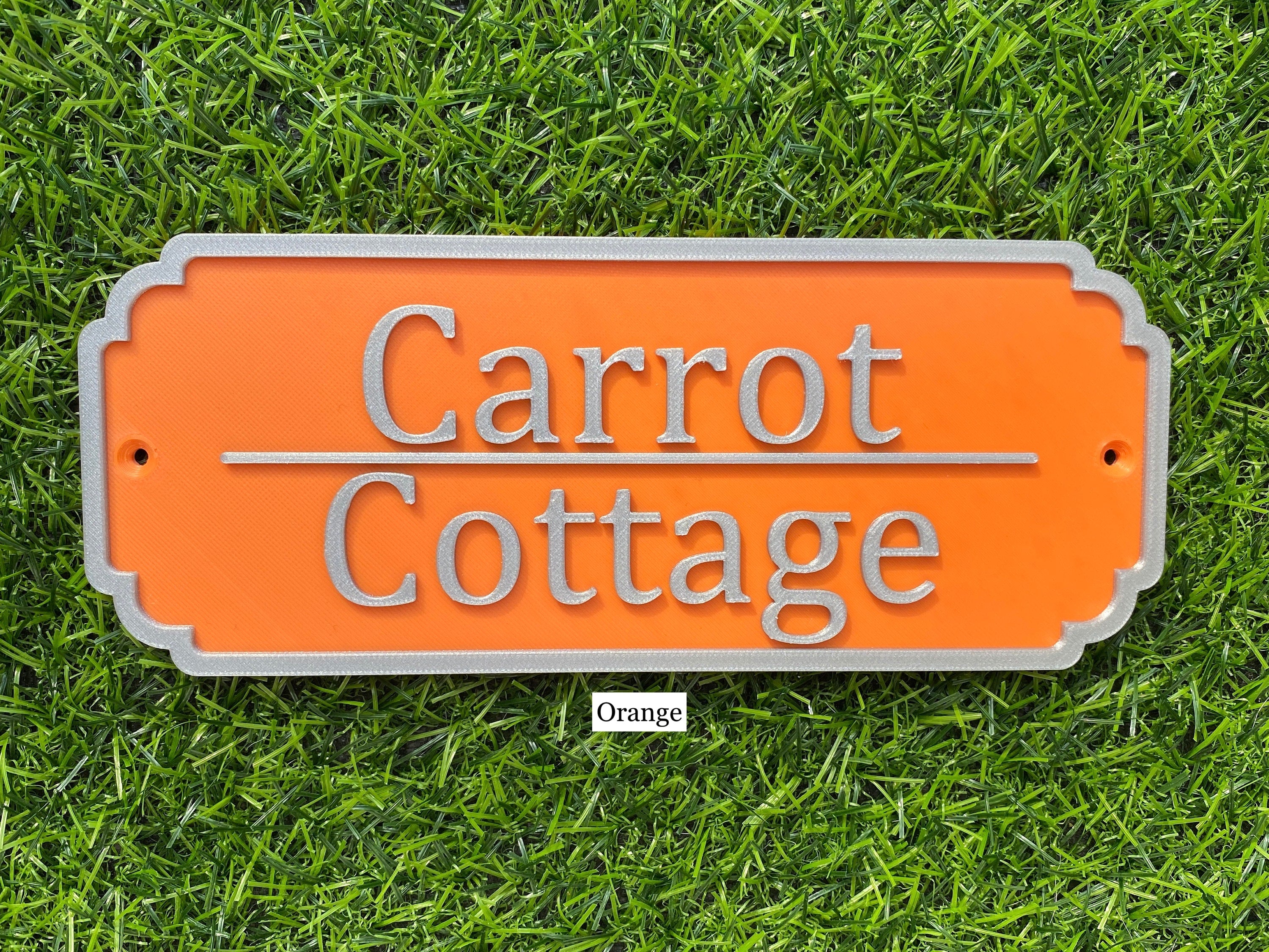 Orange rabbit hutch sign with silver lettering reading Carrot Cottage