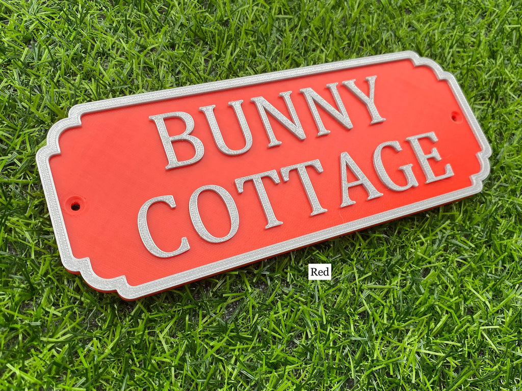 Red rabbit hutch sign with silver lettering reading Bunny Cottage
