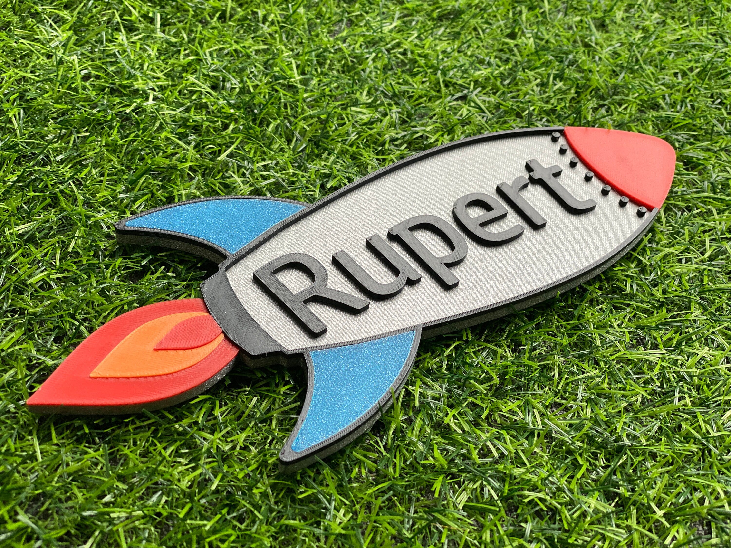 Angled view of the rocket door sign showing the raised name Rupert