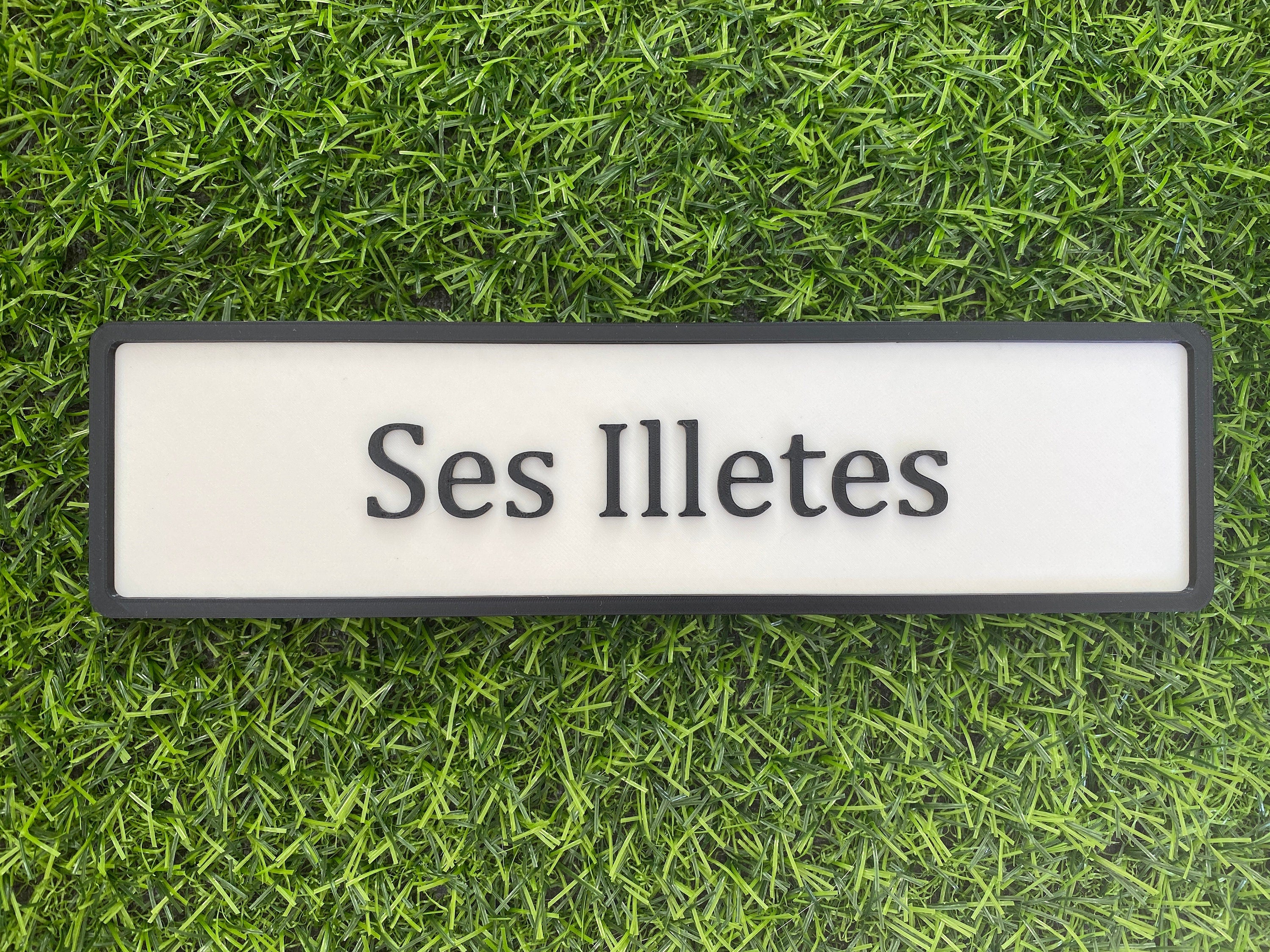 White and black contemporary door sign reading Ses Illetes