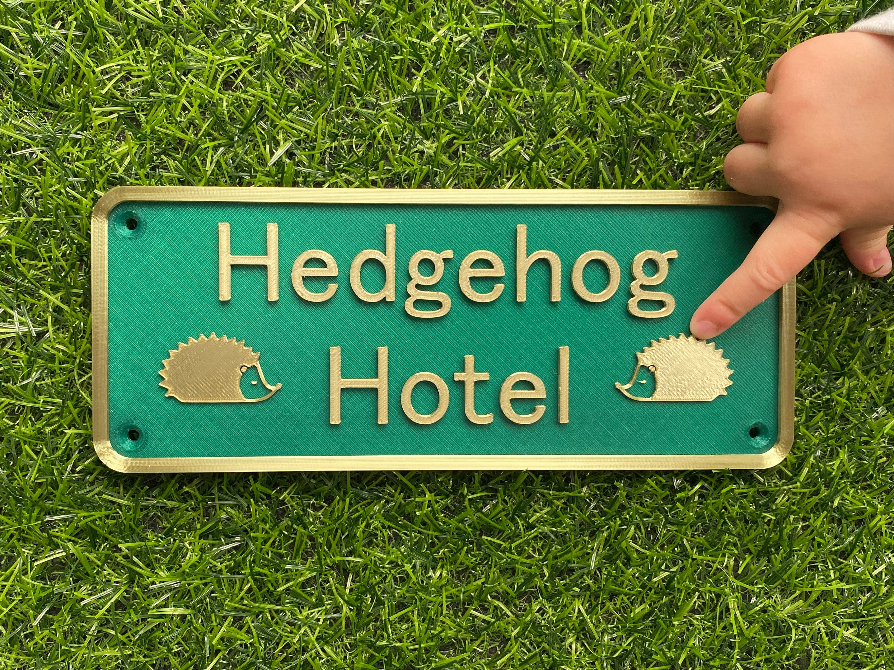 Green and gold Hedgehog Hotel sign with hedgehog motifs