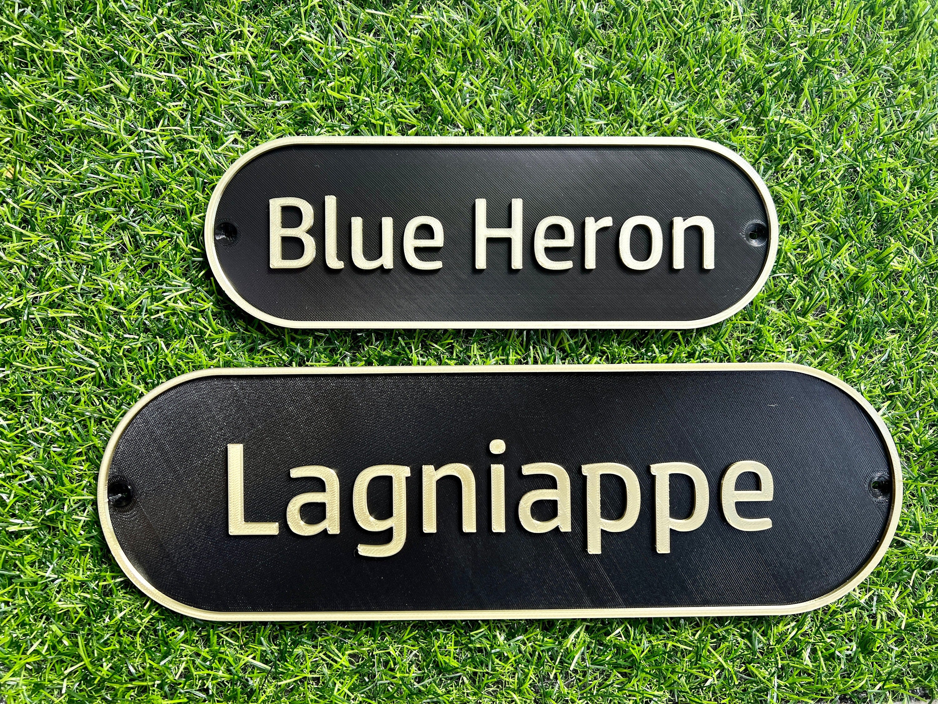 White and black retro door signs reading Blue Heron and Lagniappe