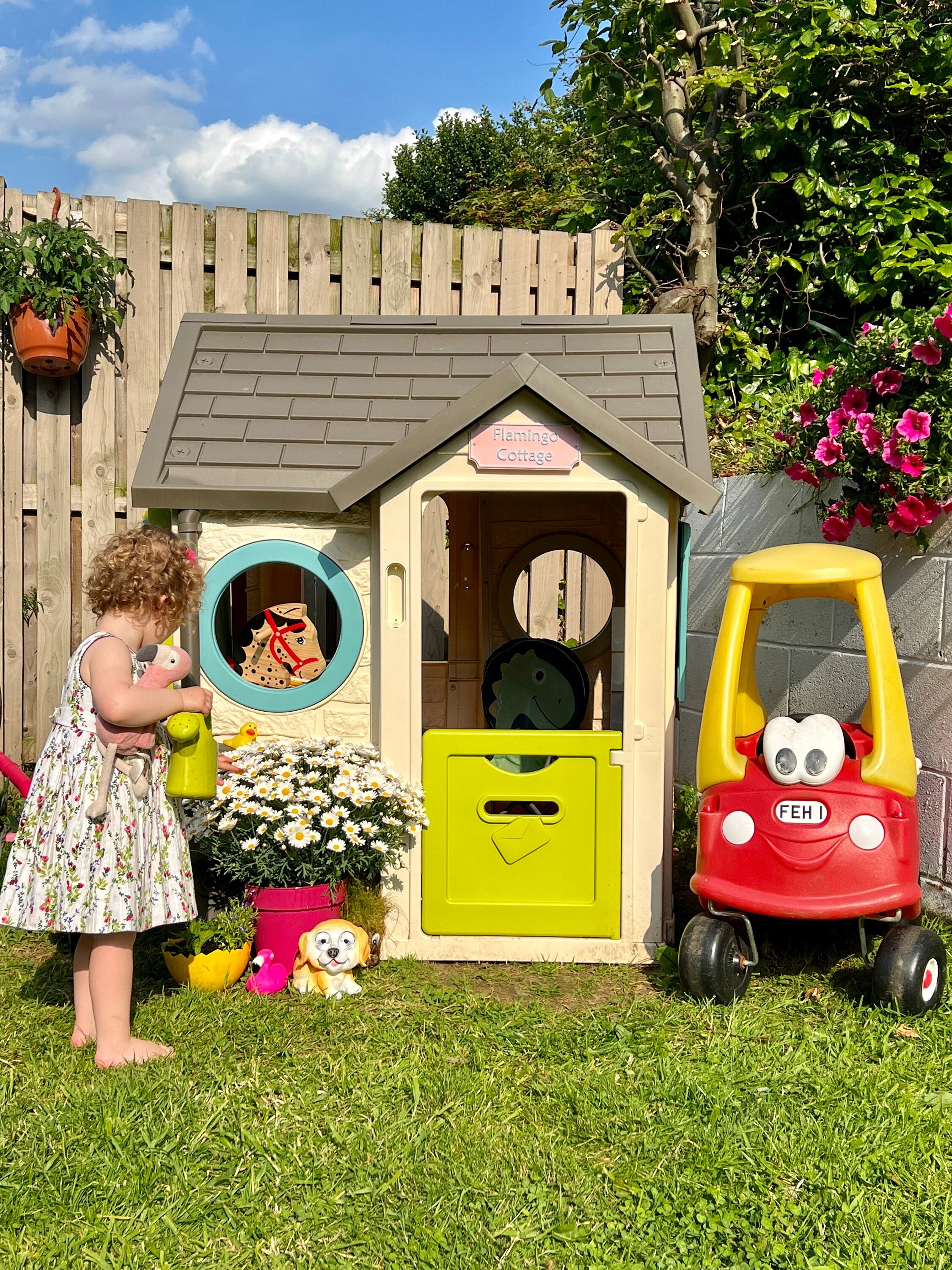 Garden playhouse fitted with a pastel pink Flamingo Cottage Emley sign