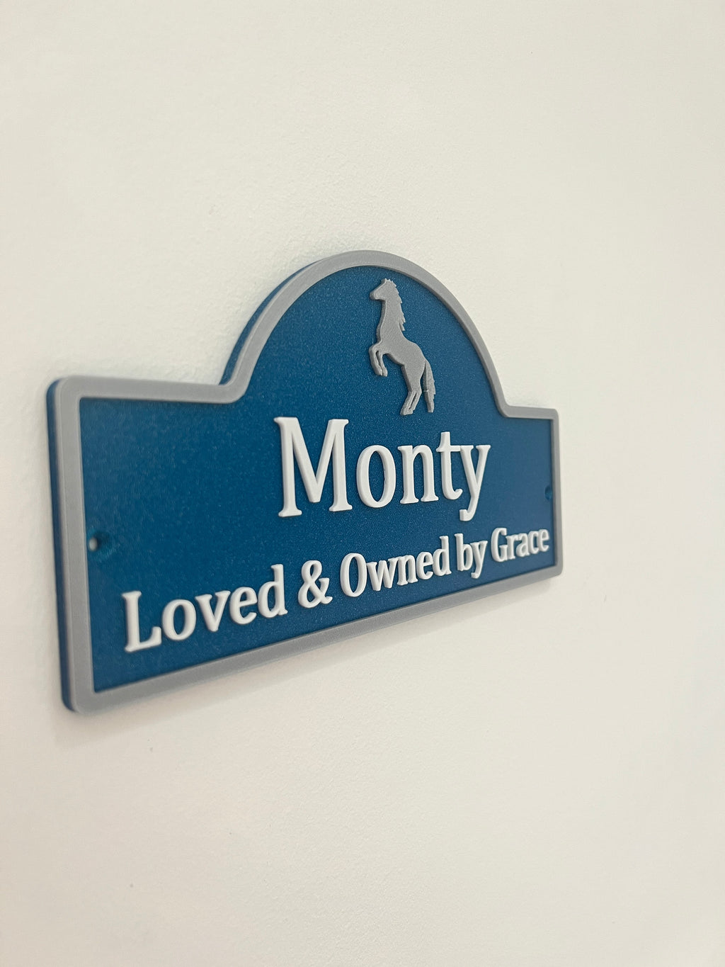 Navy sign reading Monty Loved and Owned by Grace with silver horse motif