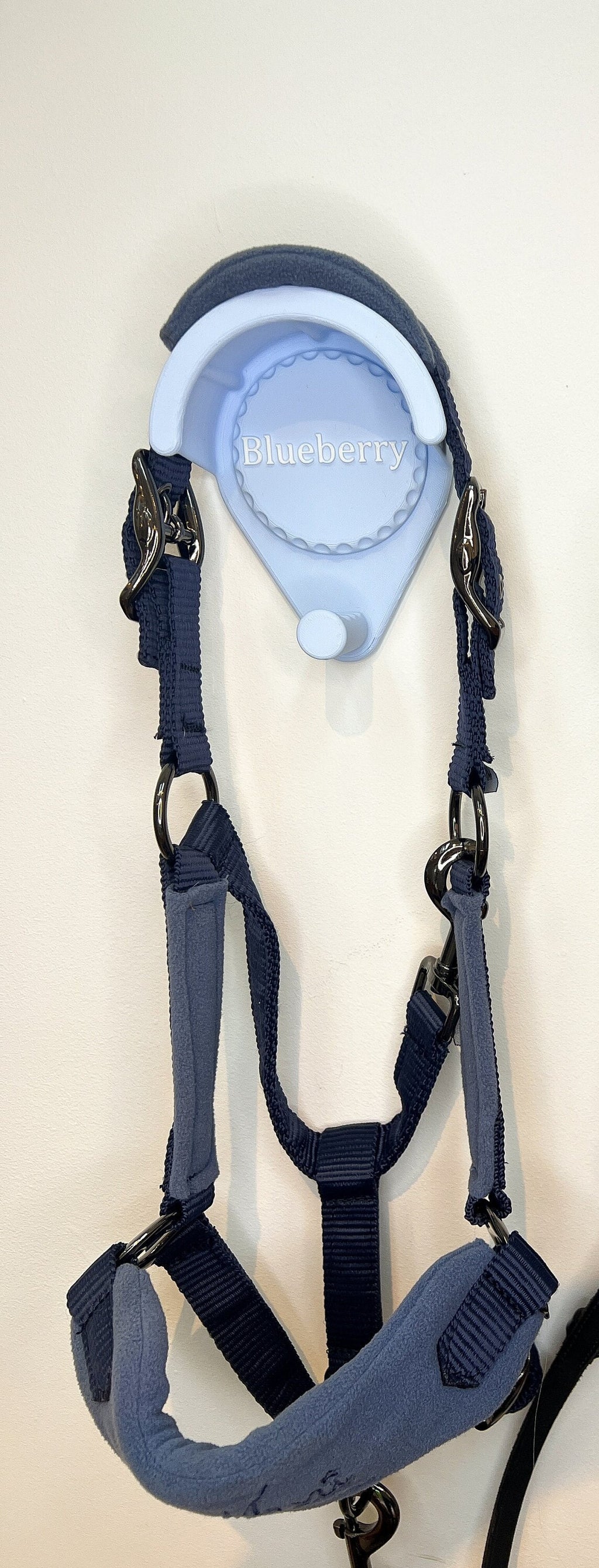 Personalised bridle holder in blue holding a navy head collar