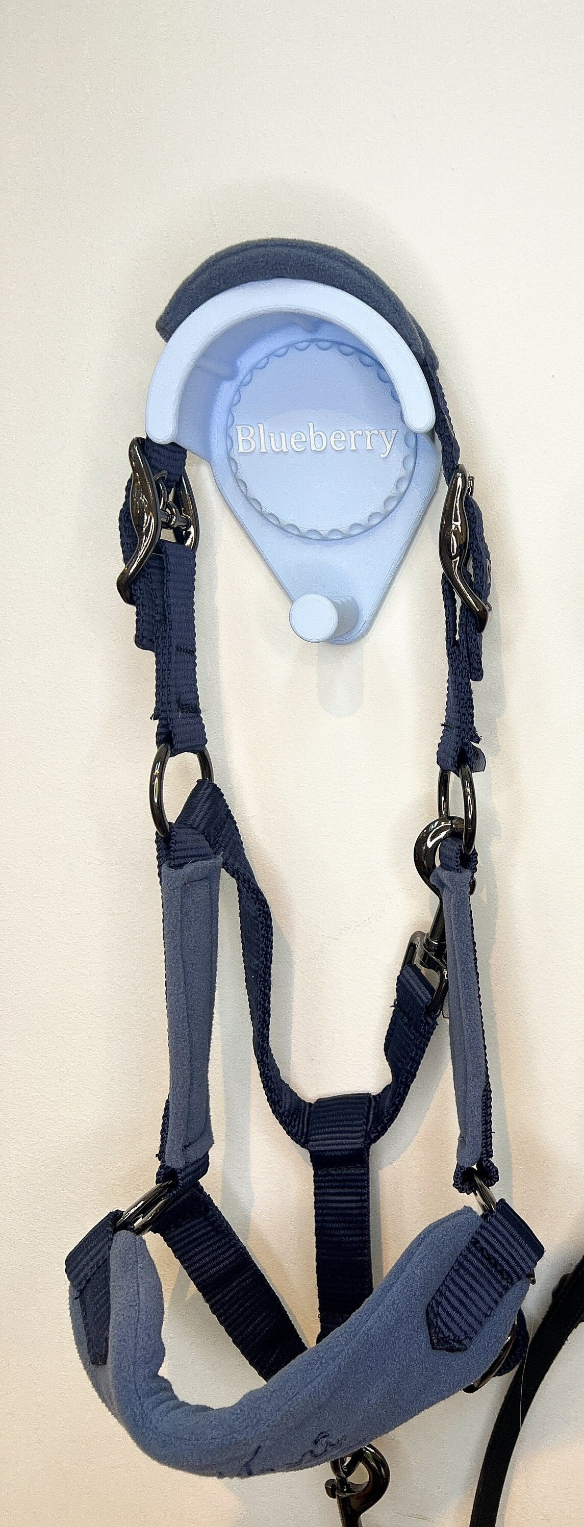 Personalised bridle holder in blue holding a navy head collar