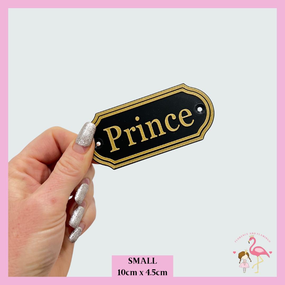 Small Traditional name plate in black and gold reading Prince, 10cm x 4.5cm